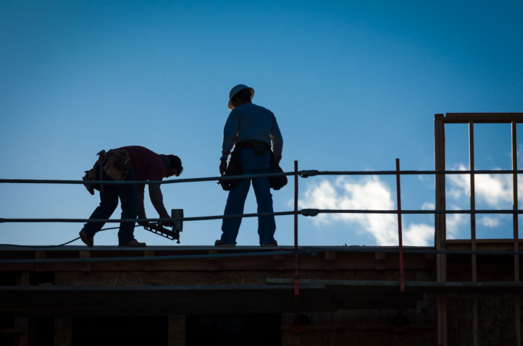 Professional roofer installing new asphalt shingles on a house
